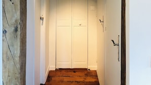 A narrow hallway with wooden beams, white walls, and a white door at the end. - Biarritz T3 Quiet + Parking + Côte des basques + Halles (Biarritz)