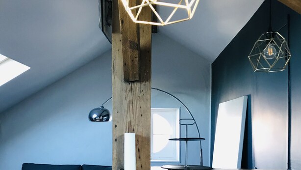 A modern loft with exposed wooden beams, a wooden dining table, and geometric pendant lights. - Biarritz T3 Quiet + Parking + Côte des basques + Halles (Biarritz)