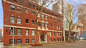 A red brick building with multiple windows and a central entrance.
