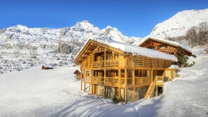 A wooden chalet with a balcony, set in a snowy mountainous area. - Chalet Argali - luxury ski-in ski-out base for 14 - OVO Network (Le Grand-Bornand)