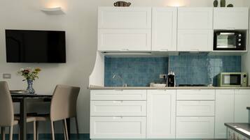 Kühlschrank, Herdplatte, Kochgeschirr/Geschirr/Besteck, Esstisch