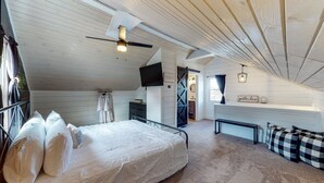 Ett sovrum med en säng, ett skrivbord, en stol och en takfläkt.