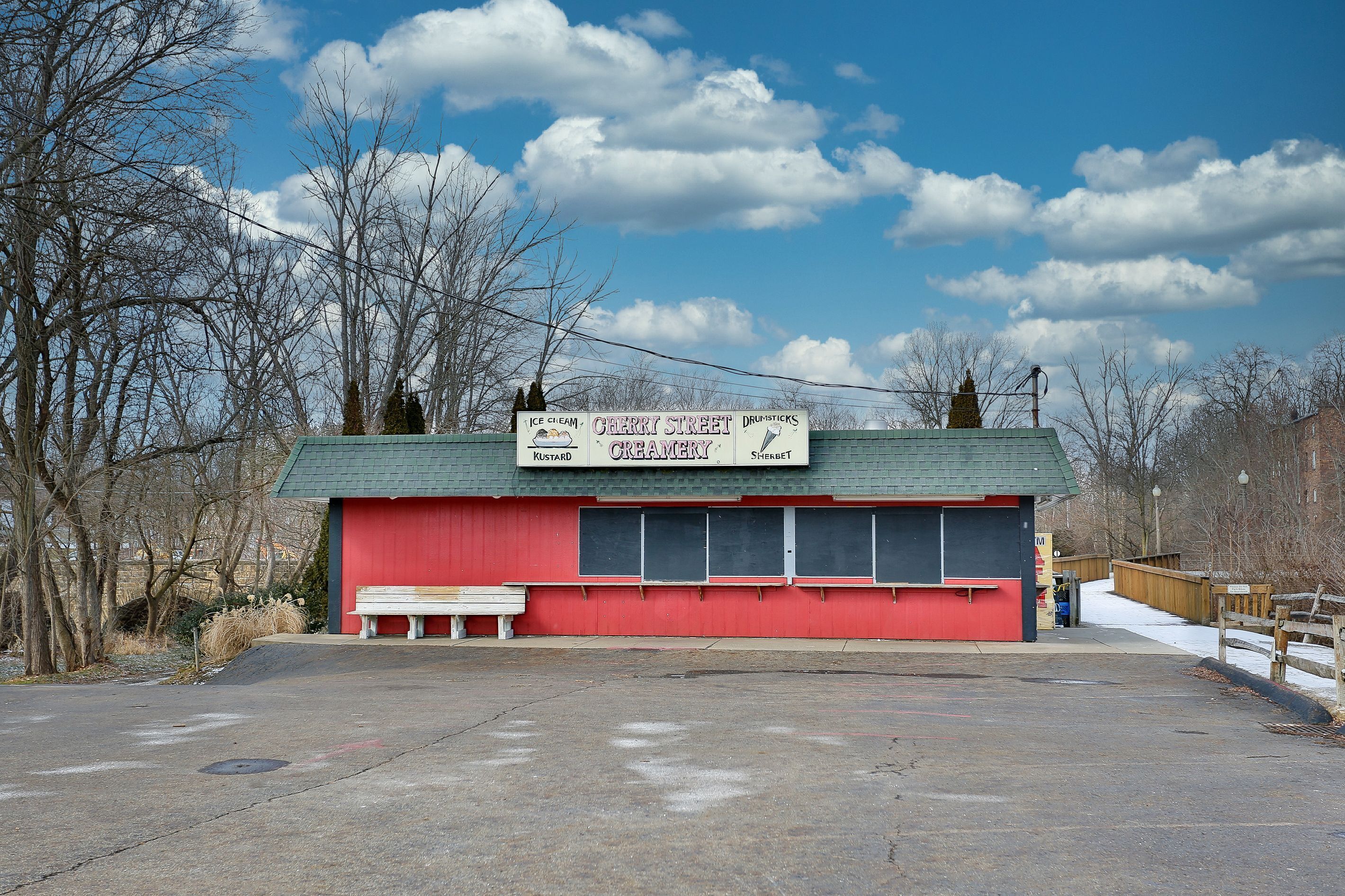 Un bâtiment rouge avec une enseigne publicitaire pour une boutique de glaces et de crèmes glacées aux cerises.