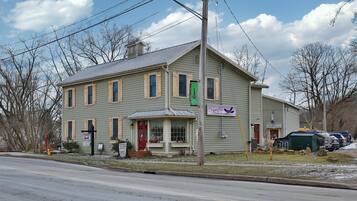 A two-story building with a gabled roof, a front porch, and a sign indicating a tea room and gift shop.
