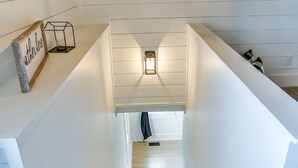 En trappa med steg klädda i matta, som leder upp till en liten plattform med en lampa och en inramad tavla.