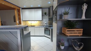 Une cuisine moderne avec des meubles blancs, un four encastré et un plan de travail doté d’un évier.