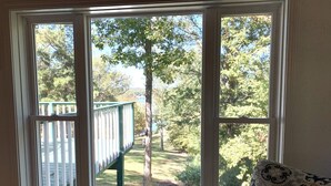 Una habitación con un ventanal que ofrece vistas a una terraza y un árbol.