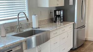 A kitchen with white cabinets, stainless steel appliances, a dishwasher, and a coffee maker. - A wonderful 3 bedroom/2 bath rental (1,000 sq (Durango)