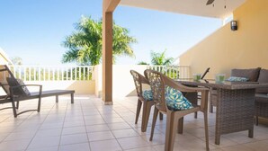 A covered outdoor patio with a dining table, chairs, and a ceiling fan. - Landing View 304 with beautiful roof top terrace (Barrio Puntas, Rincón)