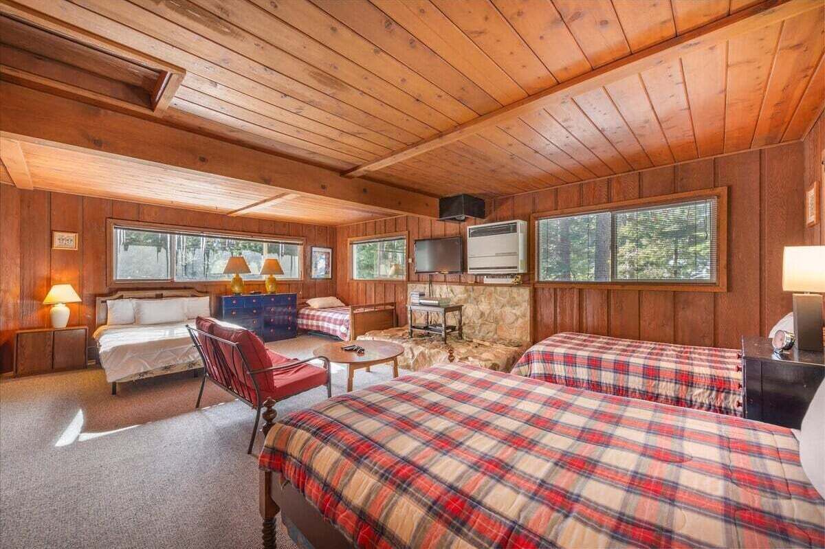 Eine Hütte mit zwei Betten, einem Fernseher und einer Steinwand.