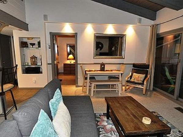 Una sala de estar moderna con sofá, mesa de centro y comedor.