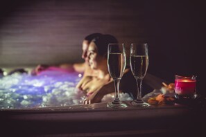 Una bañera con dos vasos de agua y una vela.