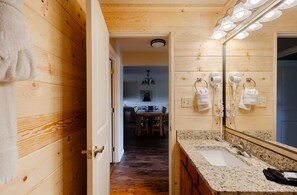 Un interior de madera con baño que incluye un lavamanos, espejo y secador de pelo.