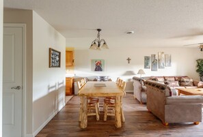 Un amplio salón con una mesa de comedor de madera, un sofá y una mesa de centro.