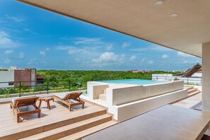 Una piscina al aire libre, sillones reclinables de piscina