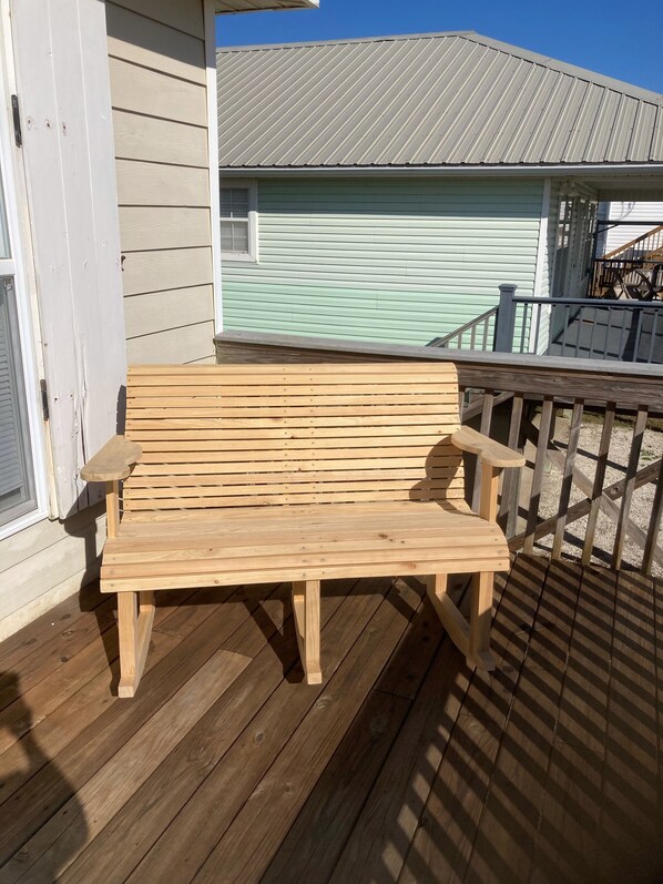 A wooden bench on a wooden deck with a house in the background. - Reel Nauti - 2BR/2BA - View of Beach and Bay (Gulf Shores)