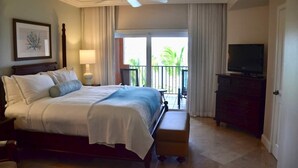 A hotel room with a bed, a television, a dresser, a ceiling fan, and a balcony with curtains. - 10% weekly disc. 2BR-Ritz-Carlton Club St. Thomas-Instant Booking- Aug 1-8, 2026 (St Thomas)