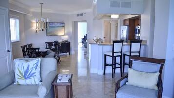 A spacious living room with a dining area, a kitchen, and a view of the dining area.