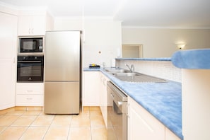 Enjoy cooking in this well-equipped kitchen with a refrigerator, oven, and microwave.