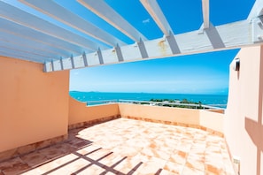 Enjoy breathtaking views of the sea and distant land from this balcony.