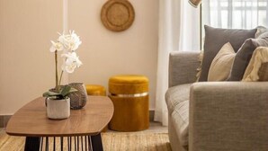 En stue med en sofa, et sofabord med en plante, og en væg med tre runde dekorationer.