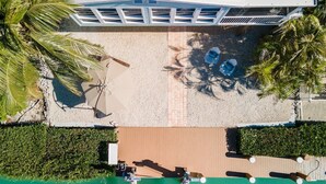 Oversigtsbillede af et resort med en pool, liggestole og palmer.