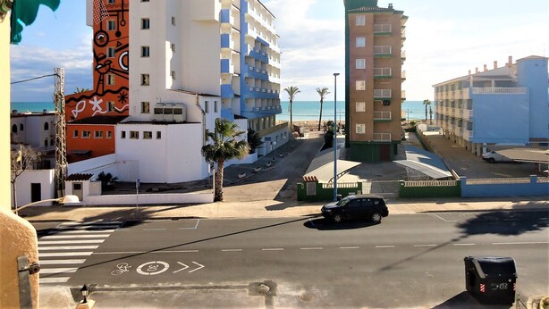 Een hotel met meerdere verdiepingen, balkons, een parkeerplaats en uitzicht op het strand.