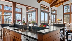 Una cucina moderna con un'isola grande, elettrodomestici in acciaio inossidabile e una lavastoviglie.