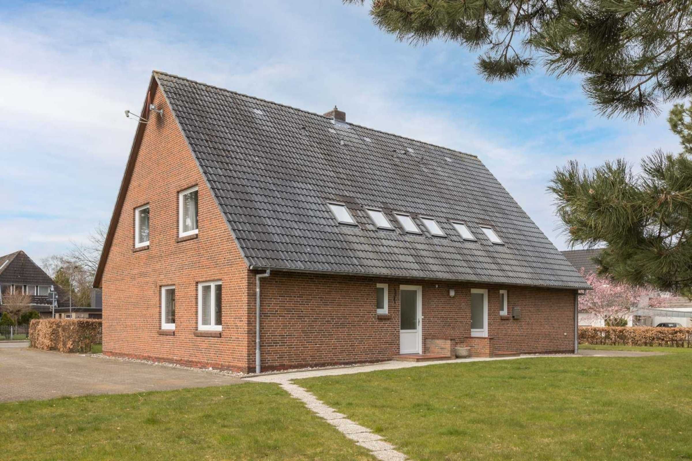 A single-story brick house with a sloped roof, a front door, and a small porch.