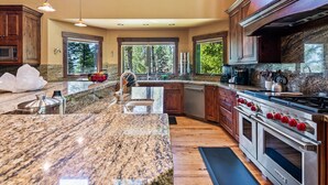 A spacious kitchen with granite countertops, a stainless steel stove, and wooden cabinets. - RMR: Sundance Ski Lodge | Luxury Ski - In / Ski - Out (Teton Village)