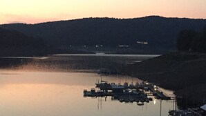 Un port de plaisance où les bateaux sont amarrés le long de la rive, entouré de collines.