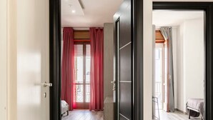 Una habitación de hotel con piso de madera, una cama, un escritorio y un armario.