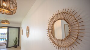 Ein Flur mit einem großen Holzspiegel und zwei kleineren Spiegeln an der Wand.