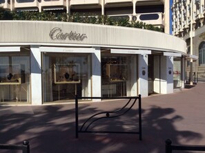 A Cartier store with a curved facade, large glass windows displaying jewelry, and a metal bench in front. - Rare gem, rooftop villa, 150m2 living space on park, janitor air-conditioning, pisc, pkg, (Cannes)