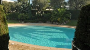 A clear swimming pool surrounded by well-maintained hedges and trees. - Rare gem, rooftop villa, 150m2 living space on park, janitor air-conditioning, pisc, pkg, (Cannes)