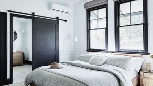 A bedroom with a bed, a ceiling fan, a window with blinds, and a wooden floor. - Benny’s Cottage  Luxury hinterland accomodation & photo shoot location (Clunes)