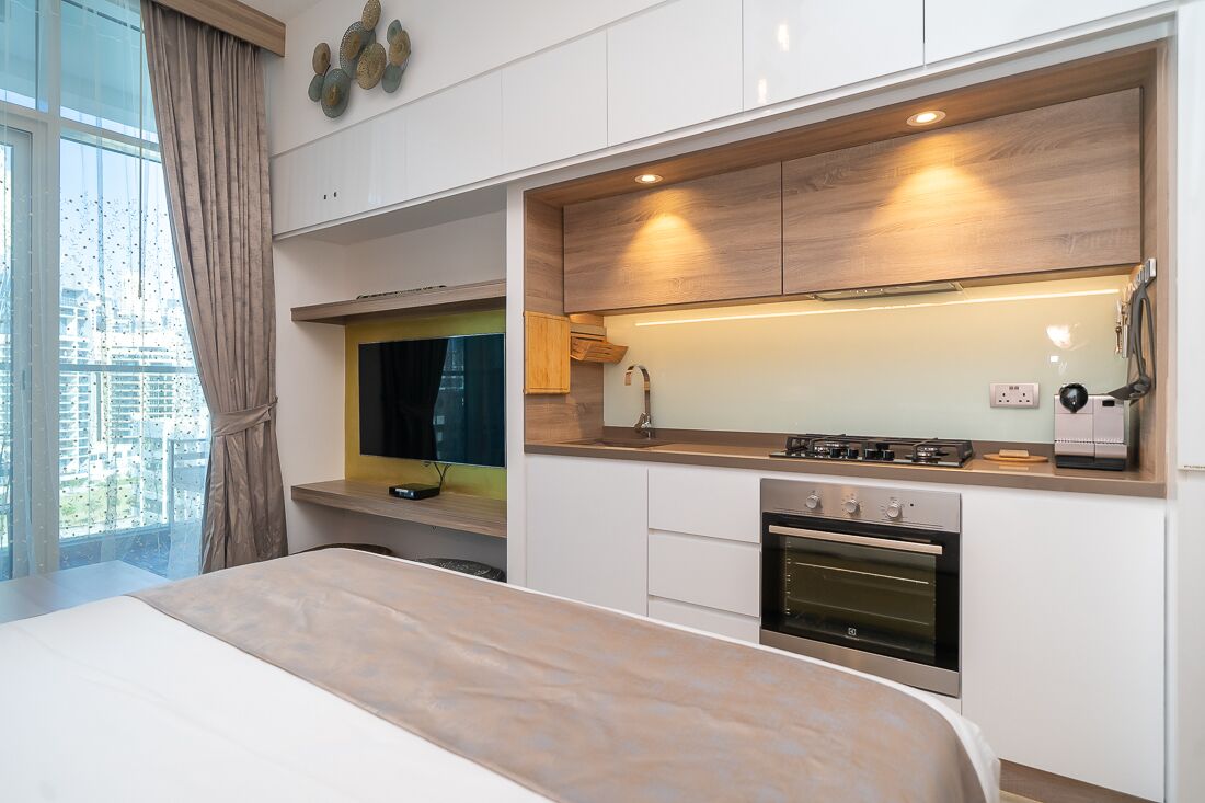 A modern kitchen with a built-in oven, a microwave, and a gas stove.