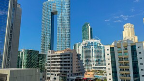Een moderne stedelijke skyline met hoge gebouwen, waaronder een opvallende cilindervormige structuur met een centrale opening.