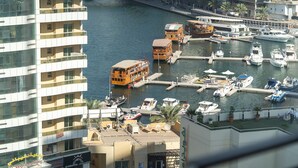 Een jachthaven met diverse boten afgemeerd, een gebouw met balkons en een helder uitzicht op het water.