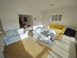 A living room with a sofa set, a yellow armchair, and a coffee table.