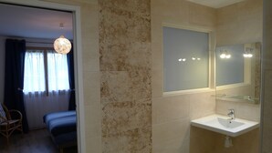 A modern bathroom with a large mirror, a sink, and a shower.