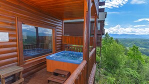 A wooden cabin with a hot tub on a deck, overlooking a forested landscape. - Legacy Mtn Resort Cabin w/ Mtn View - 2 King Beds + 2 Sofa Beds HotTub & Jacuzzi (Sevierville)