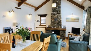 Un salon chaleureux avec une cheminée en pierre, des meubles en bois et un téléviseur.