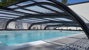 A swimming pool with a glass ceiling and a sun deck. - CONTEMPORARY VILLA HEATED POOL CLOSE TO BEACH AND FOREST (Saint-Jean-de-Monts)
