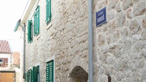 A stone building with green shutters and a sign reading "ULICA VAROS". - Frantoio House. Charming stone house in front of the dock (Betina)