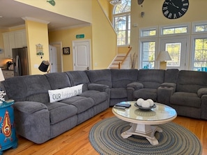 A living room with a sectional sofa, a round coffee table, and a rug. - CUSTOM HOME 3 BED/3.5 BATH ON OCEAN PT GOLF COURSE AMENITY CARDS  AVAILABLE (Fripp Island)