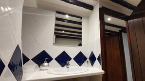 A bathroom with a white sink, a mirror, and blue diamond-patterned tiles. - Cottage with Large Drive (Wiltshire)