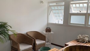 A room with a wooden bench, wicker chairs, a radio, and a green bucket. - Hotel Boutique SPA Lifestyle (RS)