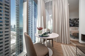 Enjoy a city view from the large window, with a comfortable armchair and sofa in this stylish room.