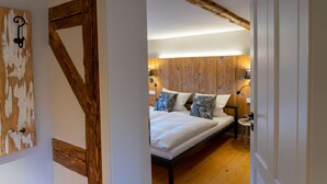 A bedroom with a wooden headboard, a bed with white bedding, and a bedside table with a lamp. - Lots of space for large families (Neusalza-Spremberg)